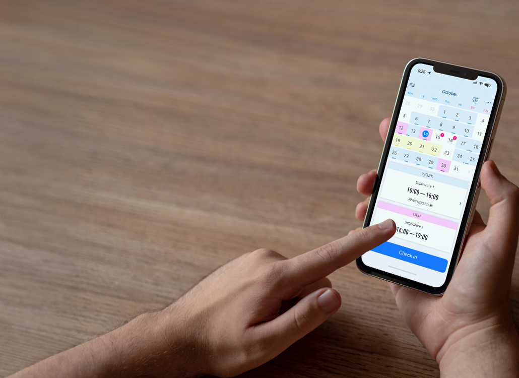 Anställd använder mobilapp med kalendervy för att registrera arbetstid – smidig och effektiv tidrapportering för lön och planering.